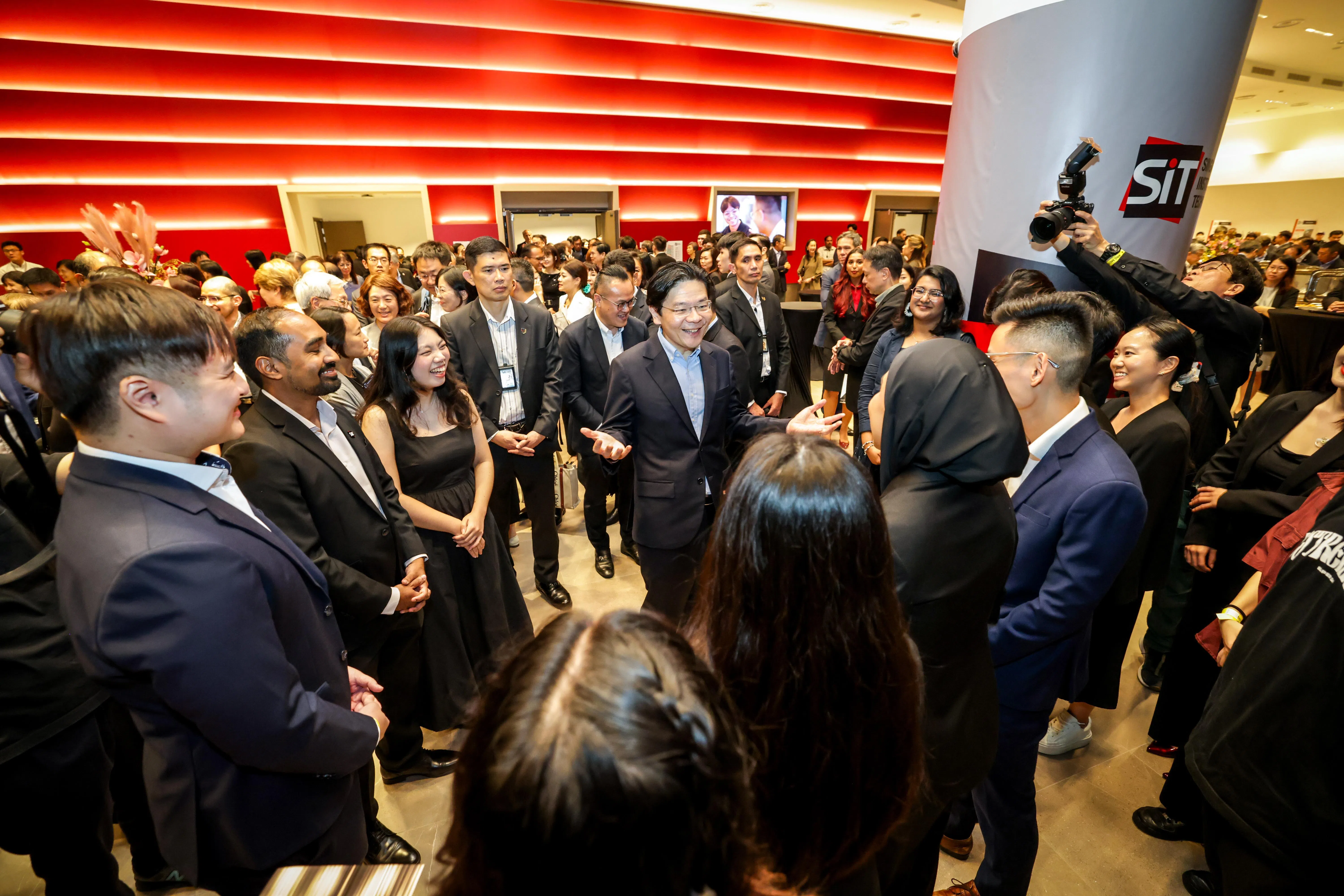 总理兼财政部长黄循财为新工大榜鹅新校舍主持开幕后，与出席者交流。（叶振忠摄）