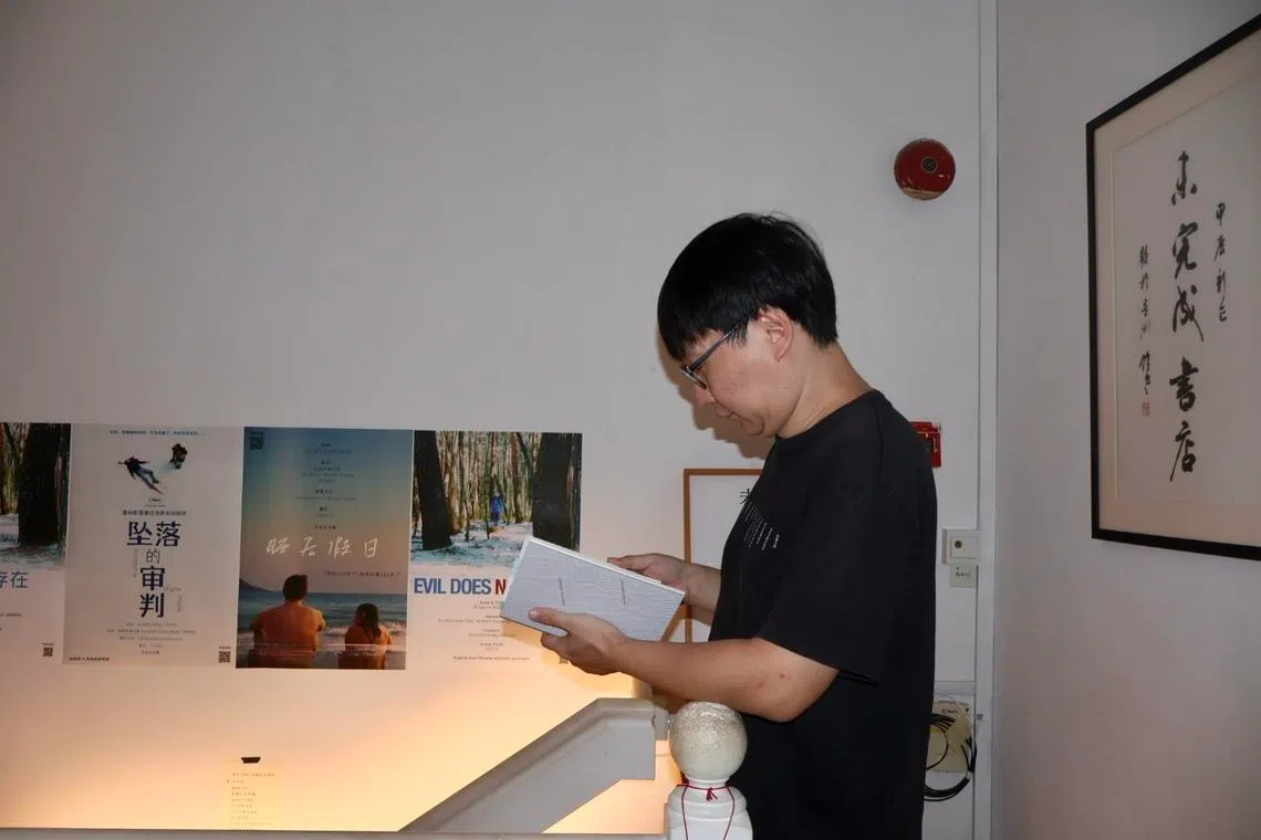 吴迪正在阅读未完成书店出品的《我星国我街道我散步》。（张子奕摄）