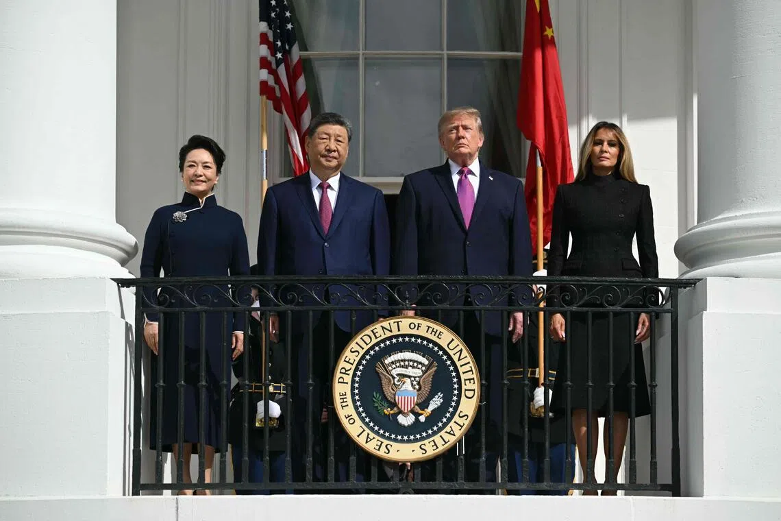 （左起）彭丽媛、习近平、特朗普和梅拉尼娅站在华盛顿白宫蓝厅阳台上，观看美国海军陆战队无声操枪排的表演。（法新社）