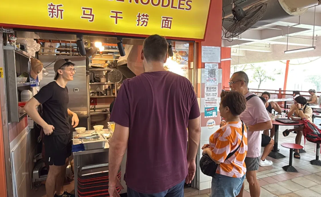 李彦智（左）高兴地向一对熟客夫妇（右）分享摊位将继续营业的消息。（萧康达摄）