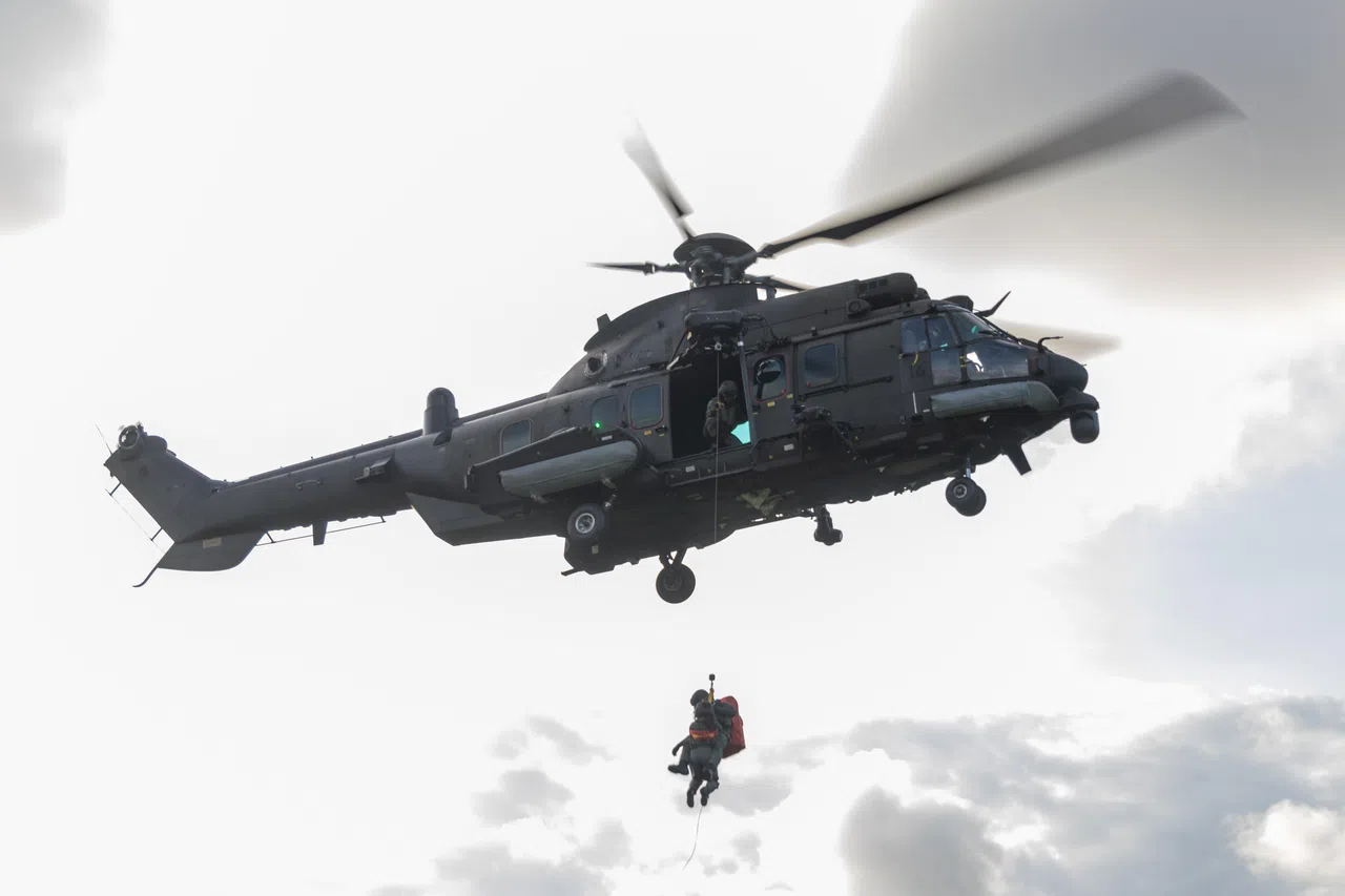 在模拟演练中，空军医务中队军医涂宇慧上尉，与高级医务员李传杰二级军事专才，从地面吊升至直升机。（吴先邦摄）