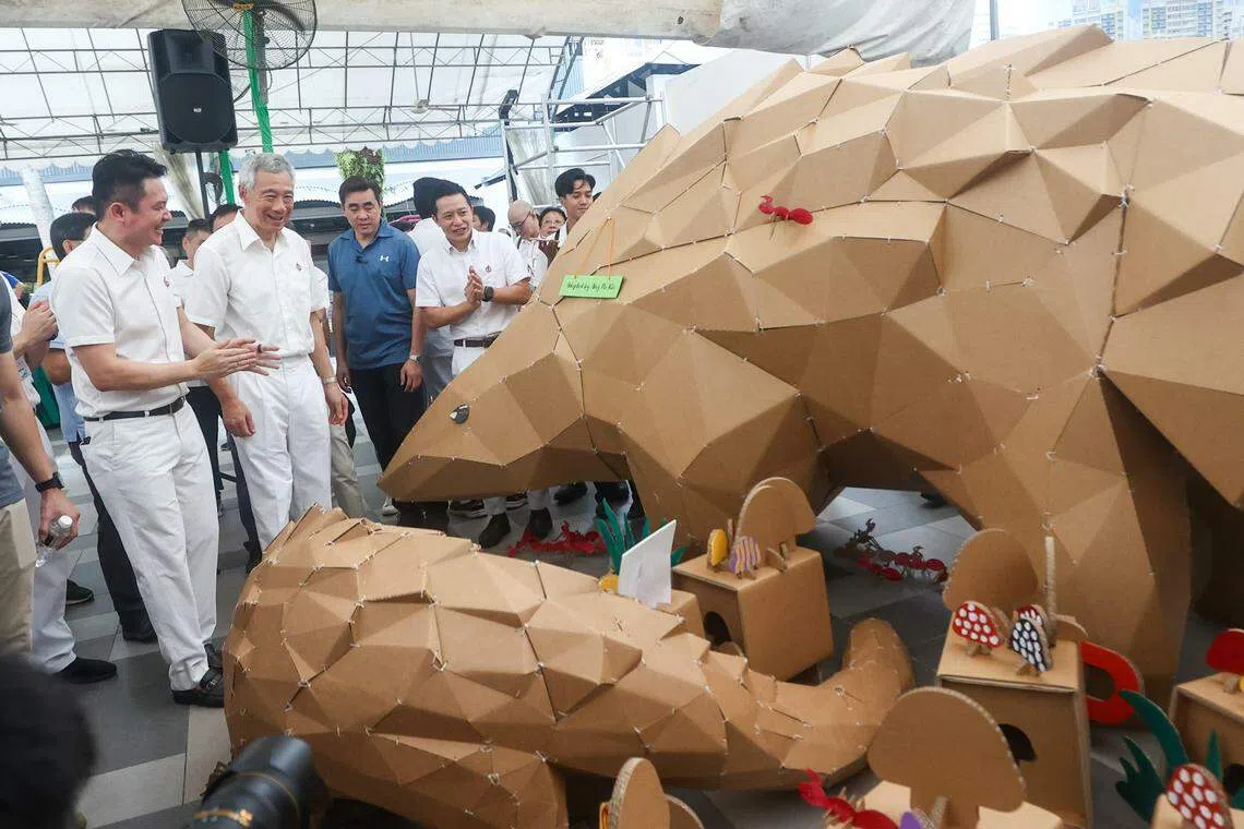 
李显龙总理（左二）参观新加坡理工学院FabLab教职员和学生制作的纸板穿山甲。由于活动要纪念李光耀为绿化新加坡所做出的贡献，团队特地挑选濒临绝种的穿山甲为主角，希望向公众传达爱护大自然的重要性。陪同参观的还有哥本峇鲁区议员郭献川（左一）与杨厝港区议员叶汉荣（左四）。（陈斌勤摄）