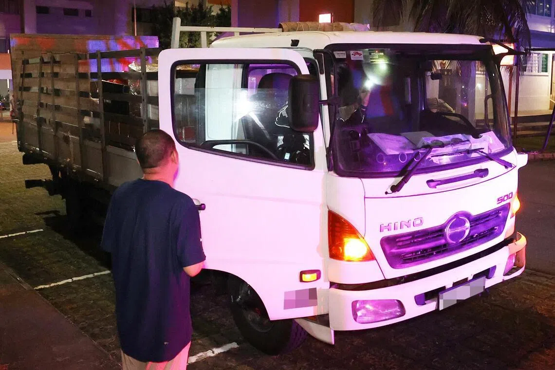 交警钻进罗厘的驾驶座内，用手电筒检查挡风玻璃处的限速器标识。（邬福梁摄）