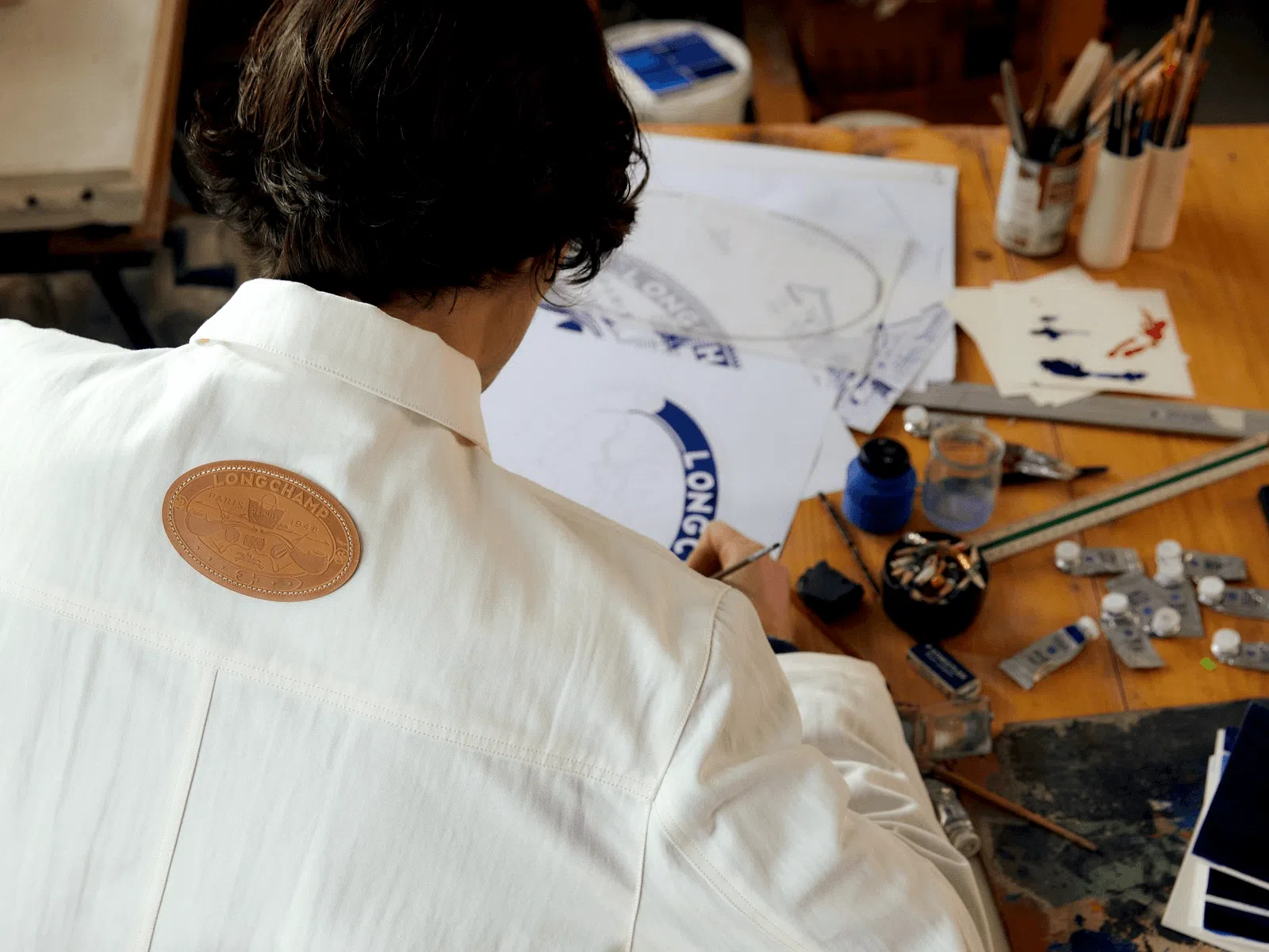 康斯坦丁手绘设计Longchamp徽章，烫印在皮革缝上联名衣饰。（Longchamp提供）