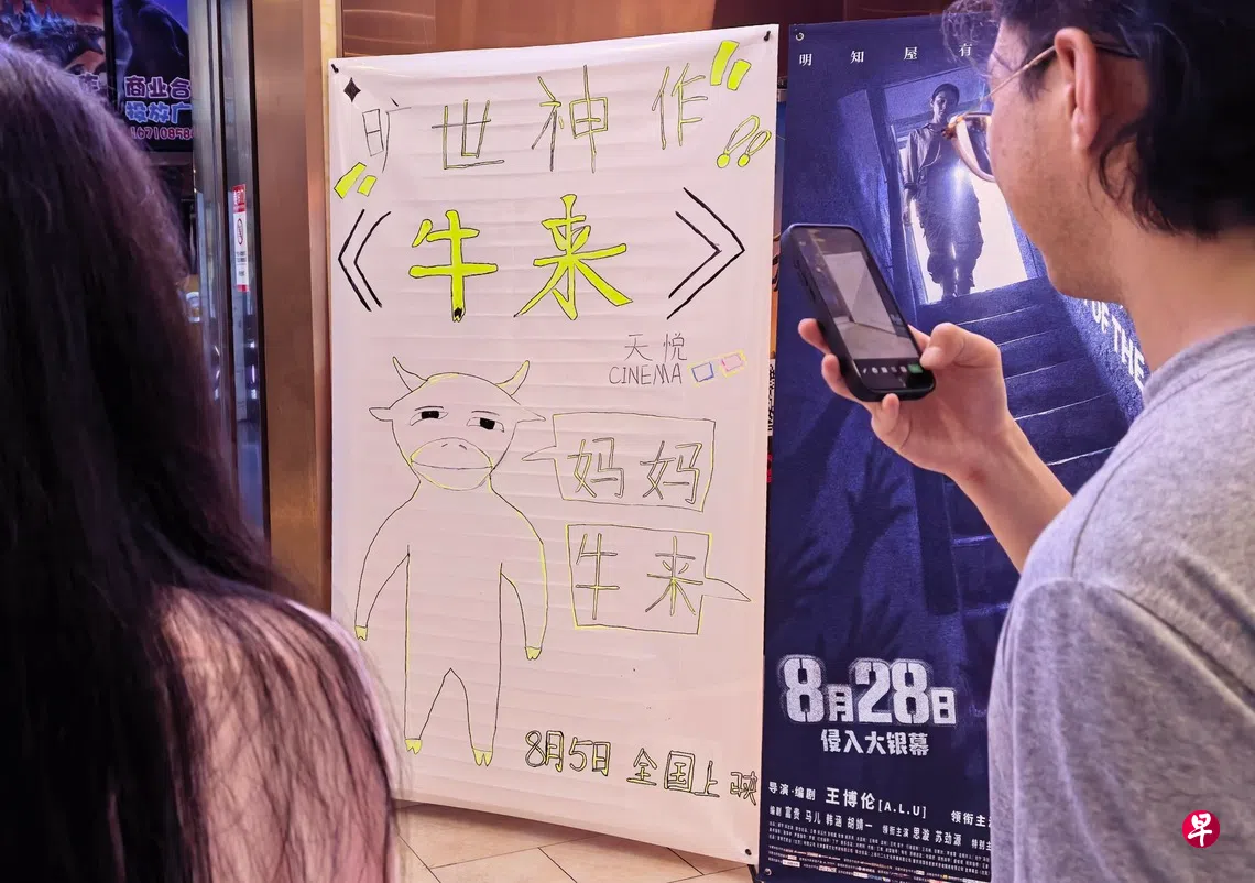 平台数据显示，截至星期天（8月23日），中国电影《牛来》累计票房已突破4200万元人民币（793万新元），观影人次超过150万。图摄于8月21日晚，北京市朝阳区一家电影院入口处摆放有电影《牛来》的手绘海报。 （中新社）