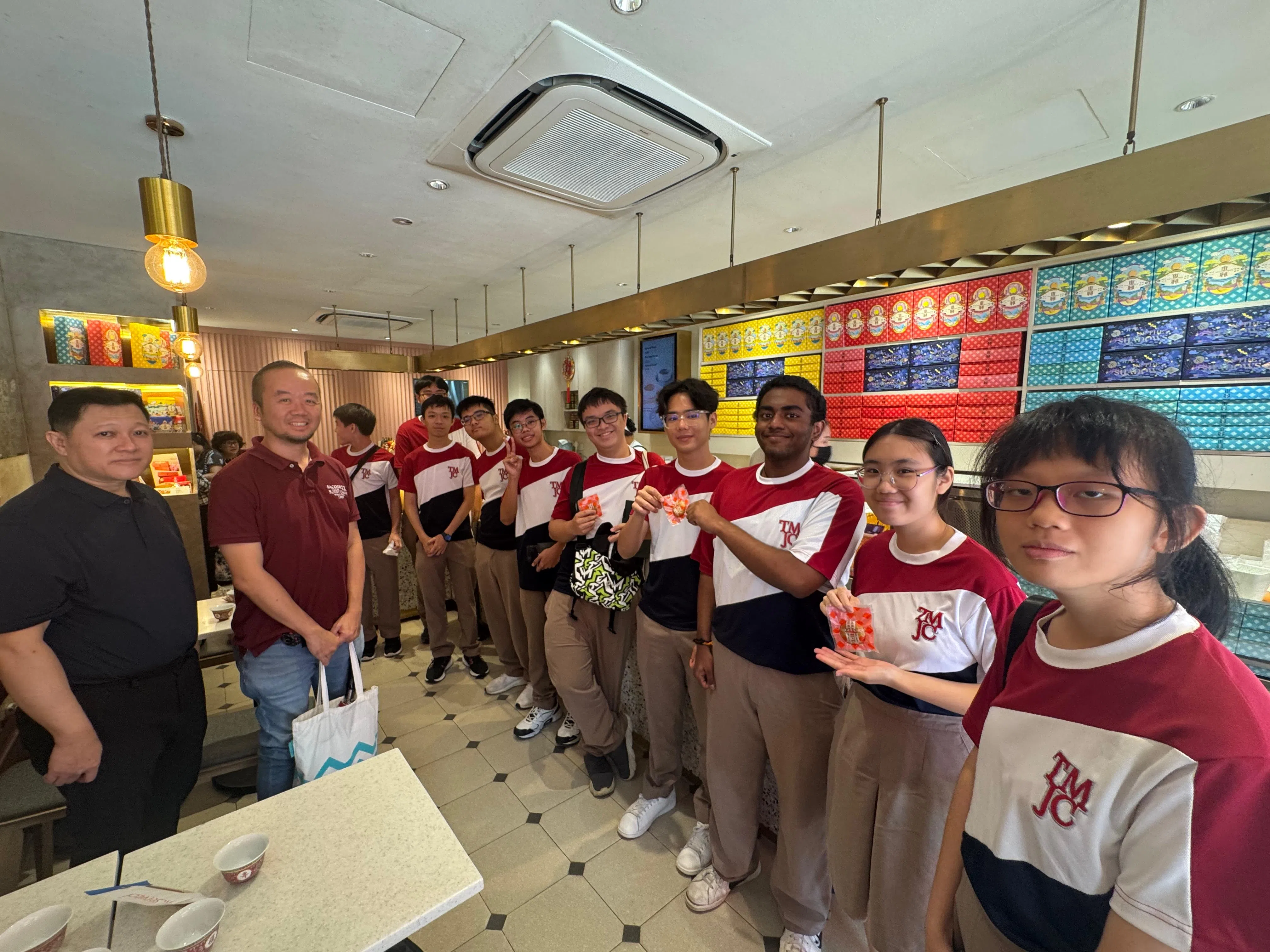 东兴饼家老板方惠强细心讲解饼家的历史，并对比最初与如今的经营方式。（联合学生通讯员摄影施策摄）