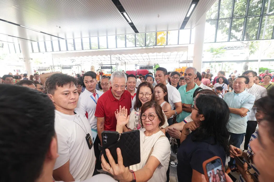 历时近四年完成翻新的杨厝港民众俱乐部重新开幕，国务资政李显龙在活动上与民众自拍。（李冠卫摄）