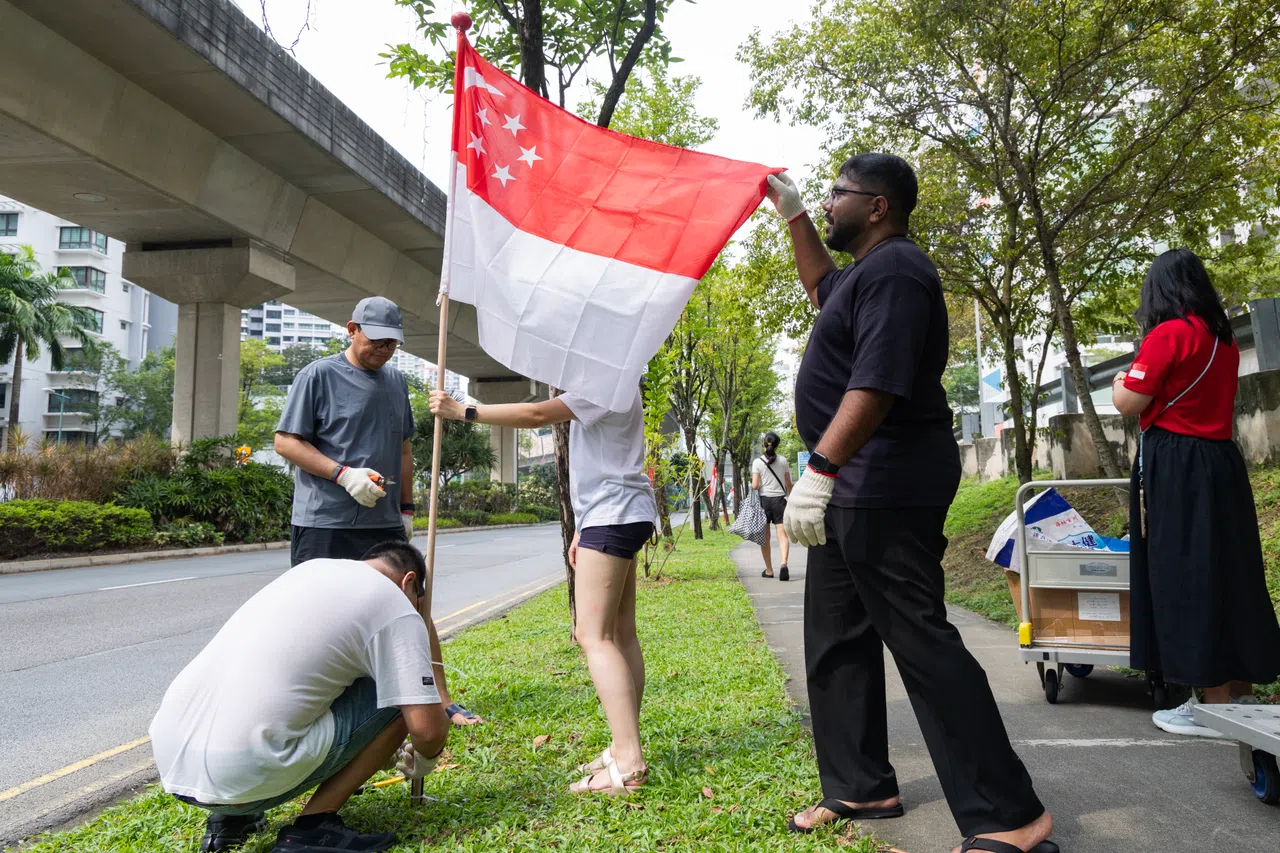 国庆日即将来临，惹兰加由社区义工在盛港西一带张挂国旗。（郑一鸣摄）