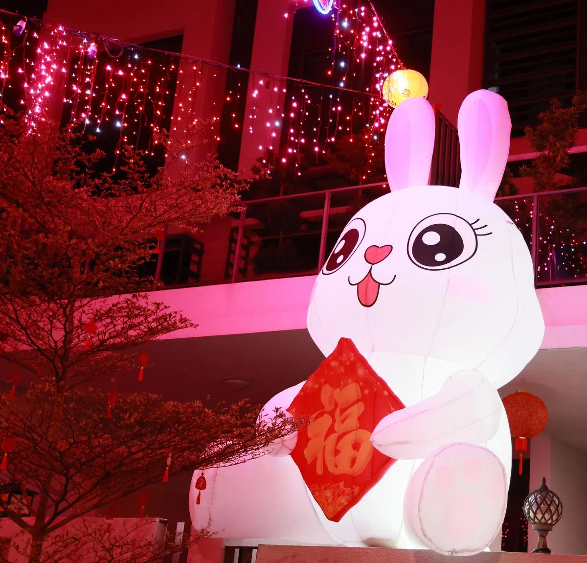 有居民在住家门口布置偌大的兔年装饰。（潘丰源摄）