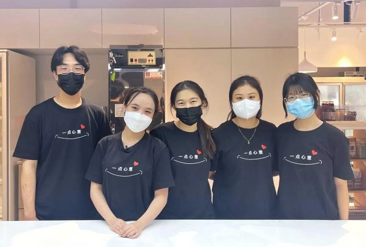 五名三年级义安理工学院学生，苏业凯（左起）、韩欣耘、陈慧欣、李宜轩与黄谦颖，通过“一点心意”的活动，以小举动鼓励上班族散发正能量。（受访者提供）