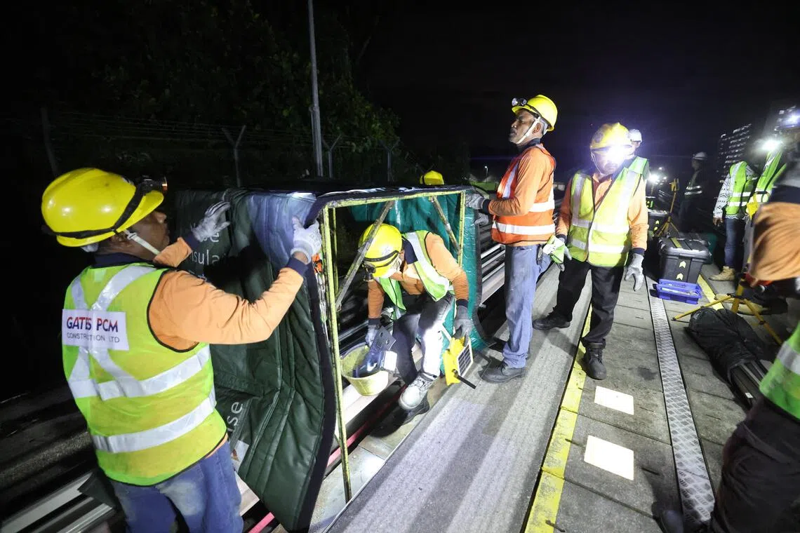 工作人员在隔音罩内切割旧供电轨，尽量减轻噪音对居民的影响。（唐家鸿摄）