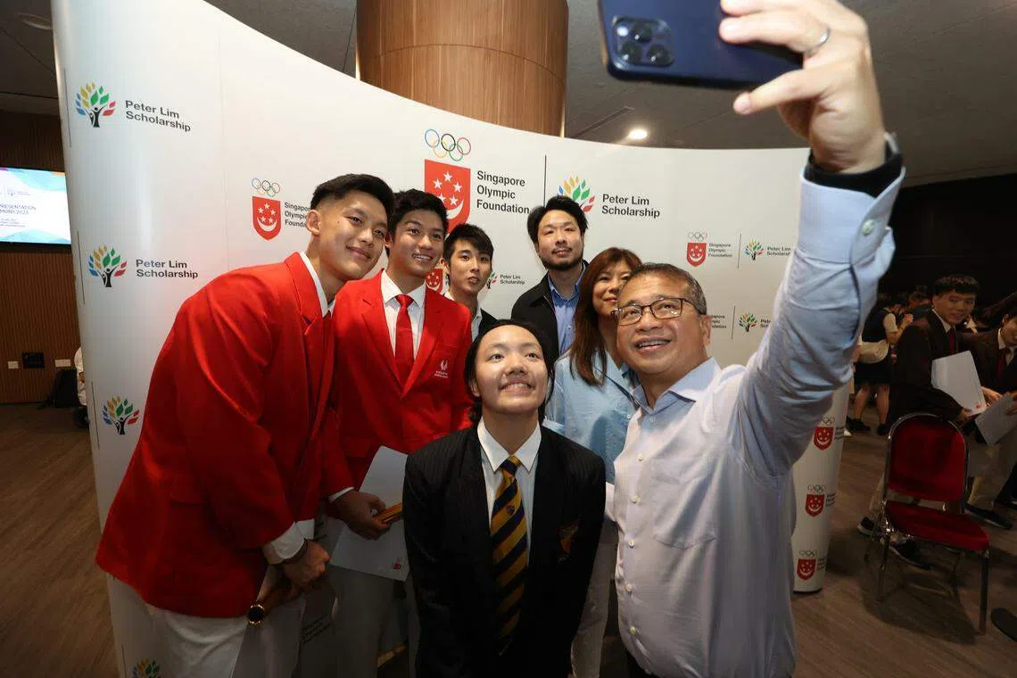 文化、社区及青年部长兼律政部第二部长唐振辉（右一）与羽毛球选手吴忠汉（左一）、帆船选手胡瑞哲（左二）、骆建佑（后排左一）、林荣福儿子林伟杰（后排右一）、林荣福太太林里嫔（右二）、游泳选手林乙暄（中）合影留念。（梁麒麟摄）