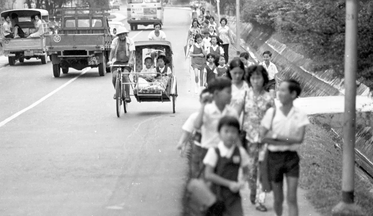 70年代的路上，除了步行、搭公交，家境较宽裕的孩子，还可以乘三轮车上学。（档案照片）