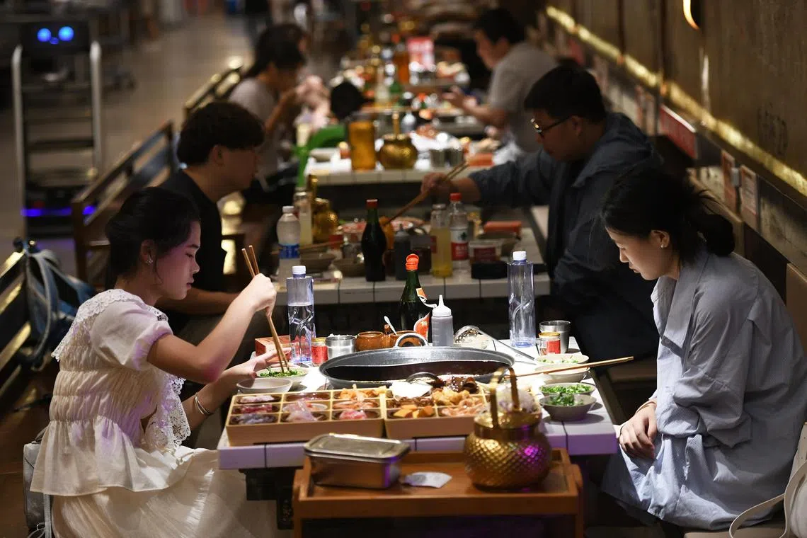 中国一些非一线城市的餐饮消费增势迅猛，例如重庆今年上半年餐饮消费就同比增长11.9%。图为重庆民众8月15日在防空洞内吃火锅。（中新社）