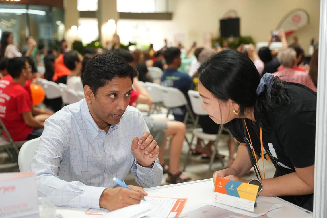 人力部兼文化、社区及青年部政务部长迪内希（左）也当场登记成为骨髓捐献者。（谢智扬摄）