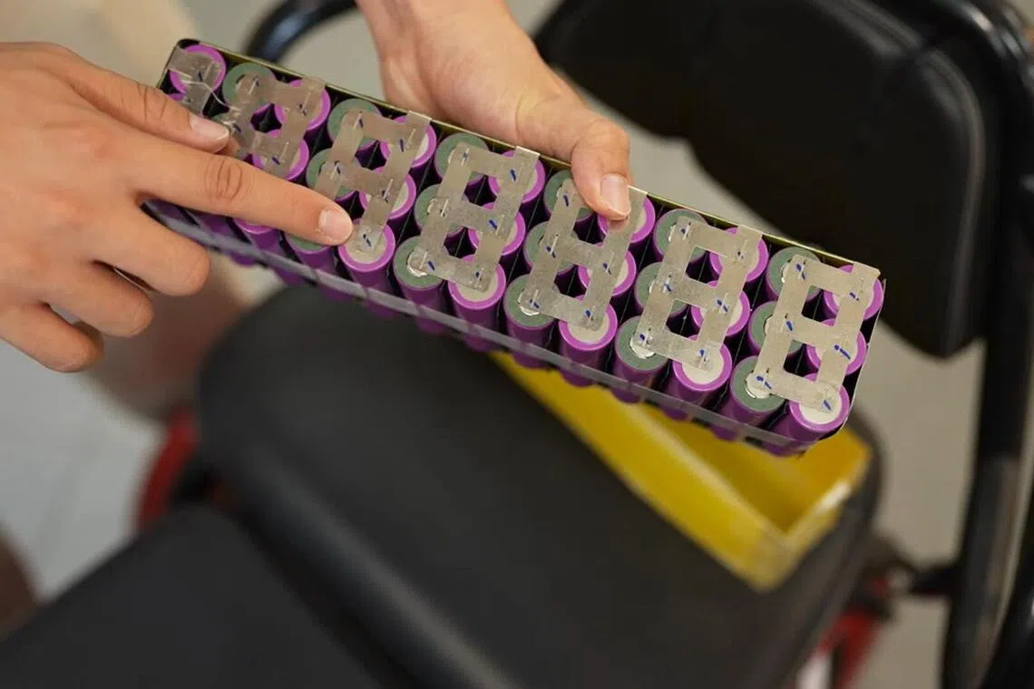 赖昂展示违规活跃通勤工具改装用的电池，由一颗颗成排的锂电池组装而成。（视频截图）