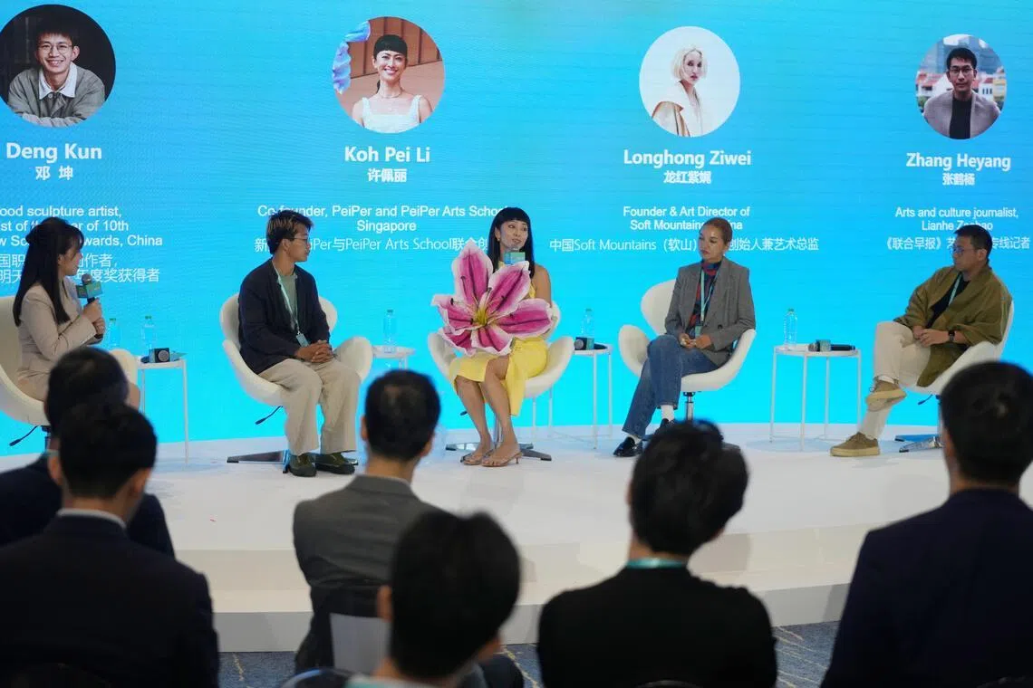 “中新青年说”圆桌对话会第二场讨论围绕传统文化当代焕新展开，参与讨论的包括中国职业木雕创作者邓坤（左二起），新加坡纸艺与综合媒体艺术家许佩丽，中国彝族设计师、软山品牌创始人龙红紫娓、《联合早报》艺术文化专线记者张鹤杨；主持讨论的是《人民日报》记者韩晓萌（左一）。（谢智扬摄）