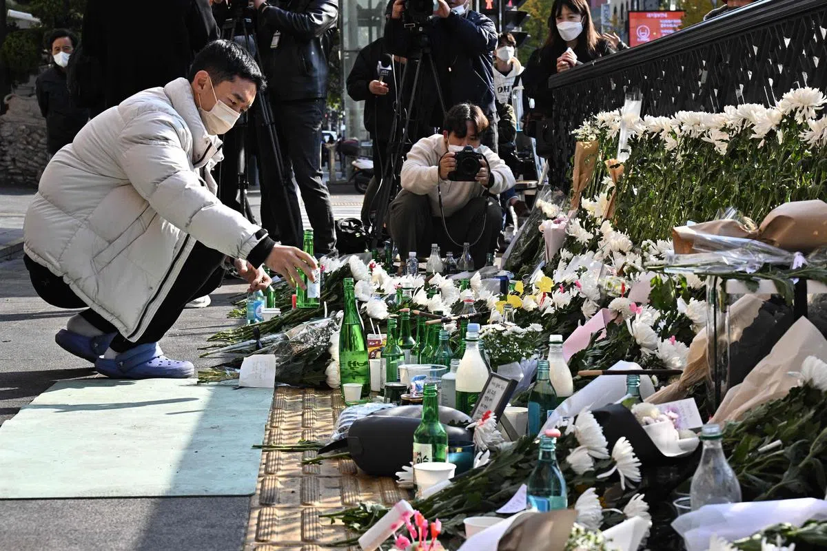 首尔梨泰院踩踏事故发生后隔天，首尔市民纷纷到事发地点用花束、小卡片悼念罹难者。（路透社）