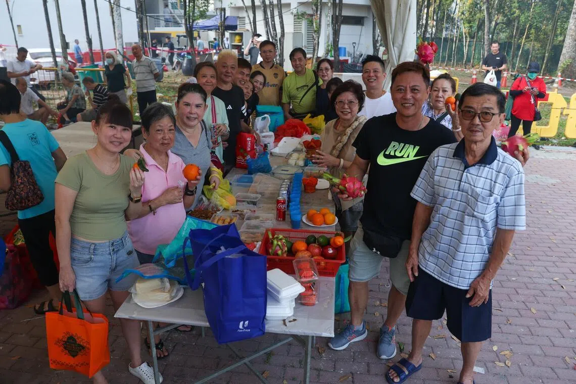 梁氏家族共17人，从各区出发齐聚蔡厝港骨灰瓮安置所，成员分工摆放祭品并进行祭拜仪式。（白艳琳摄）
