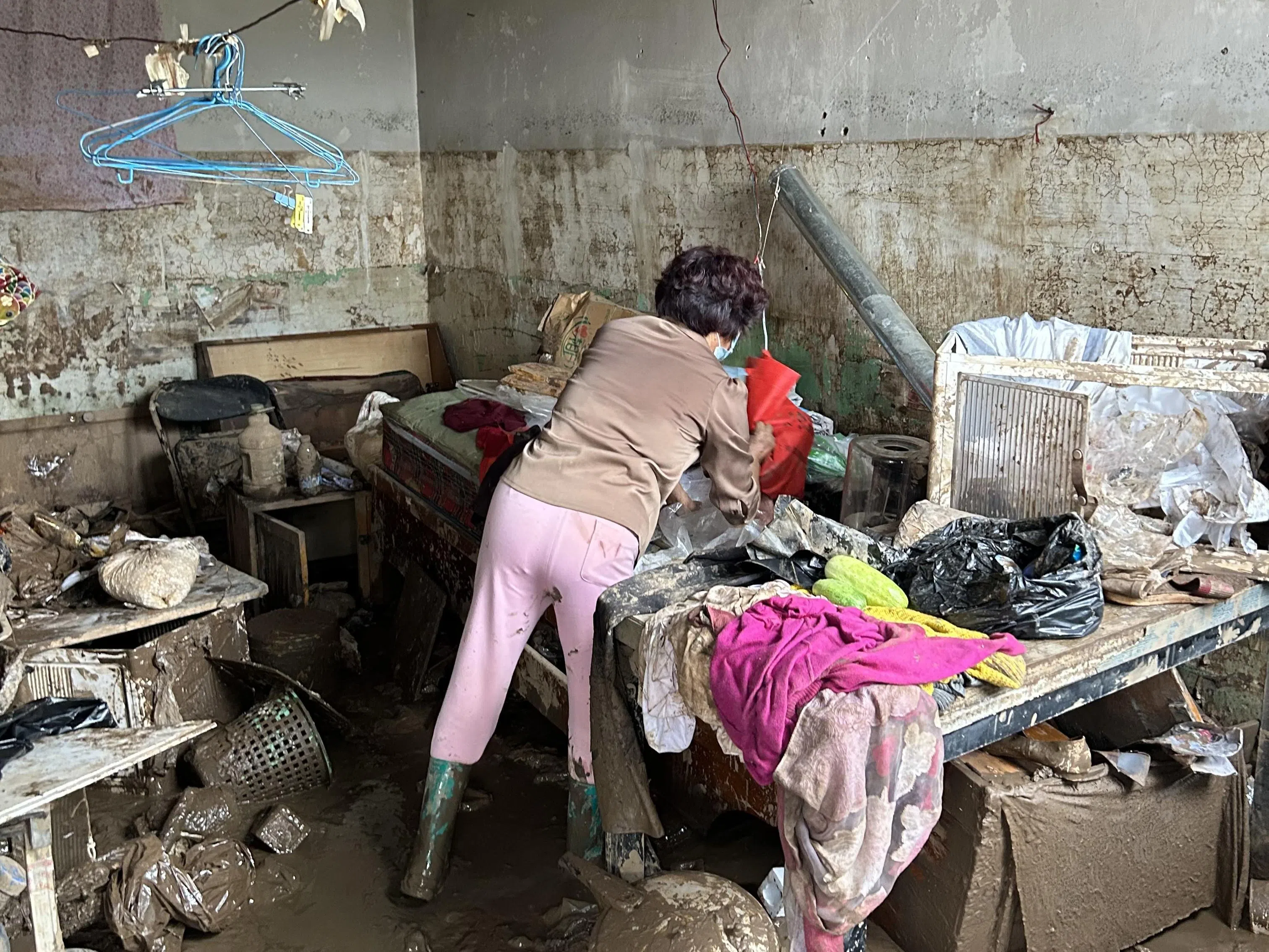 马大娘星期一（8月4日）回家收拾杂物，家中物品都沾满污泥。（周岳翔摄）