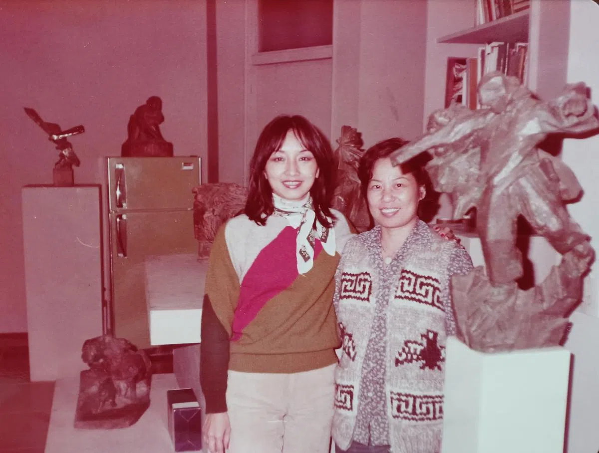 1981年朱铭家中客厅的朱太太陈富美（右）和高信疆太太柯元馨（左），后方冰箱上为朱铭1961年以新婚太太为对象雕刻作品《玩沙的女孩》原件。（作者提供）