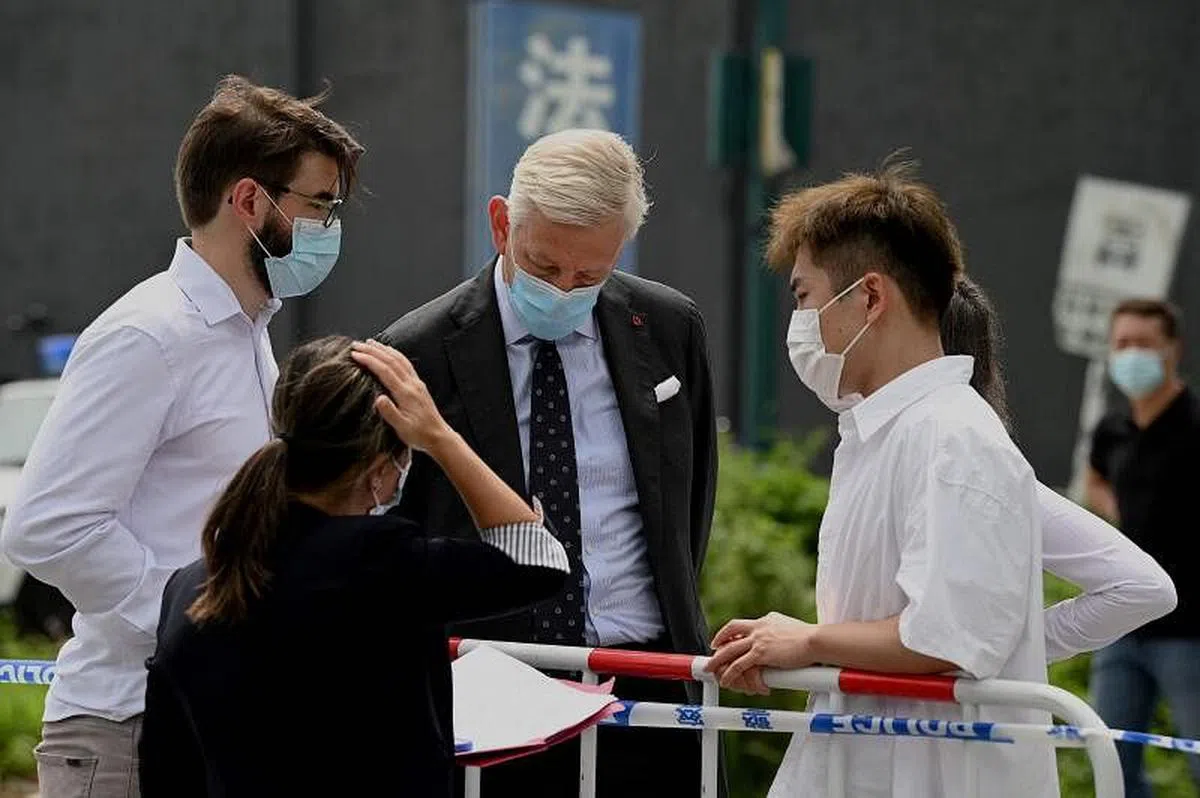 加拿大驻华大使鲍达民在判决后探望了斯帕弗。图为鲍达民（中）在丹东看守所外与使馆工作人员交谈。（法新社）