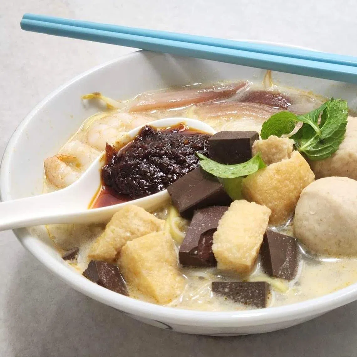 槟城白咖喱面汤底奶白，还有在新加坡吃不到的猪血。（陈爱薇摄）