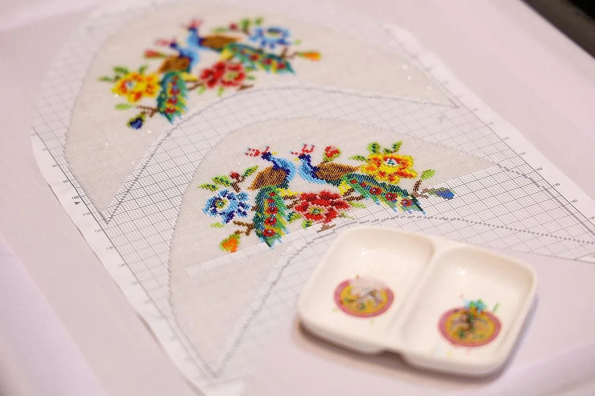 一针一线把比豆还细小的彩珠拼成一幅美丽的鞋面图案需要极大的耐心和精湛的手艺。（蔡家增摄）