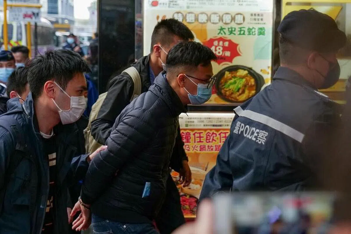 《立场新闻》现任署理总编辑林绍桐 (中) 今早被警员带回《立场新闻》办公楼。（法新社）