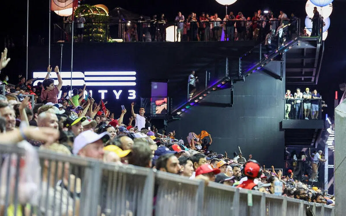 现场观众聚精会神观看排位赛，也有人拿出手机记录下珍贵画面。（张思庆摄）