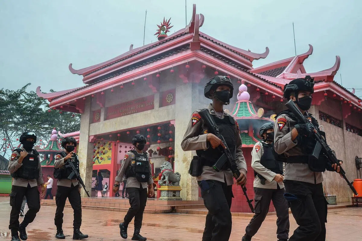 大年初一，印尼警察在廖内省北干巴鲁的一座寺庙外巡逻，防止不法之徒在佳节期间滋事。（法新社）