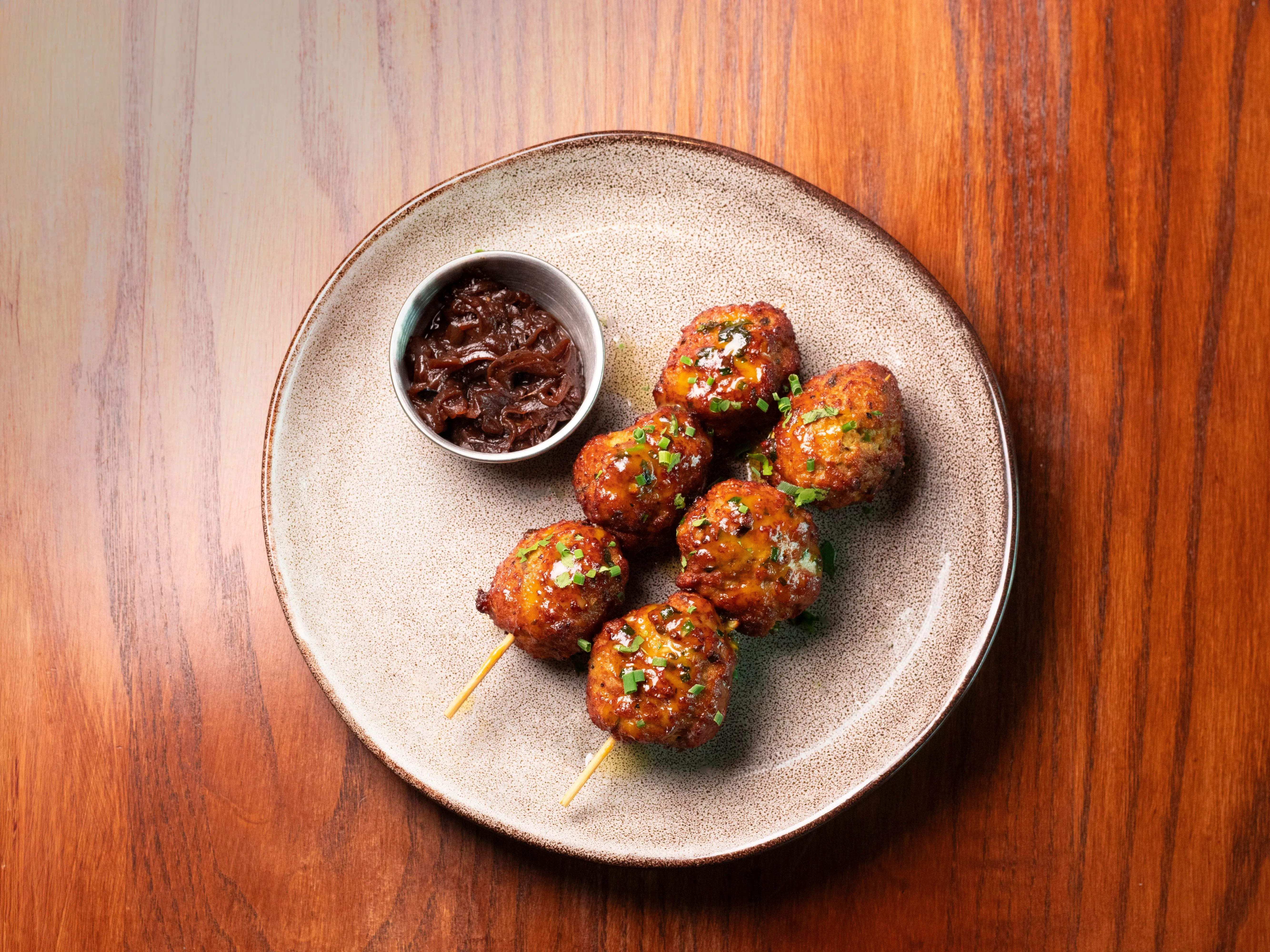 Anticuchos De Albondigas炭烤鸡肉丸串搭配甜润洋葱果酱。（餐馆提供）