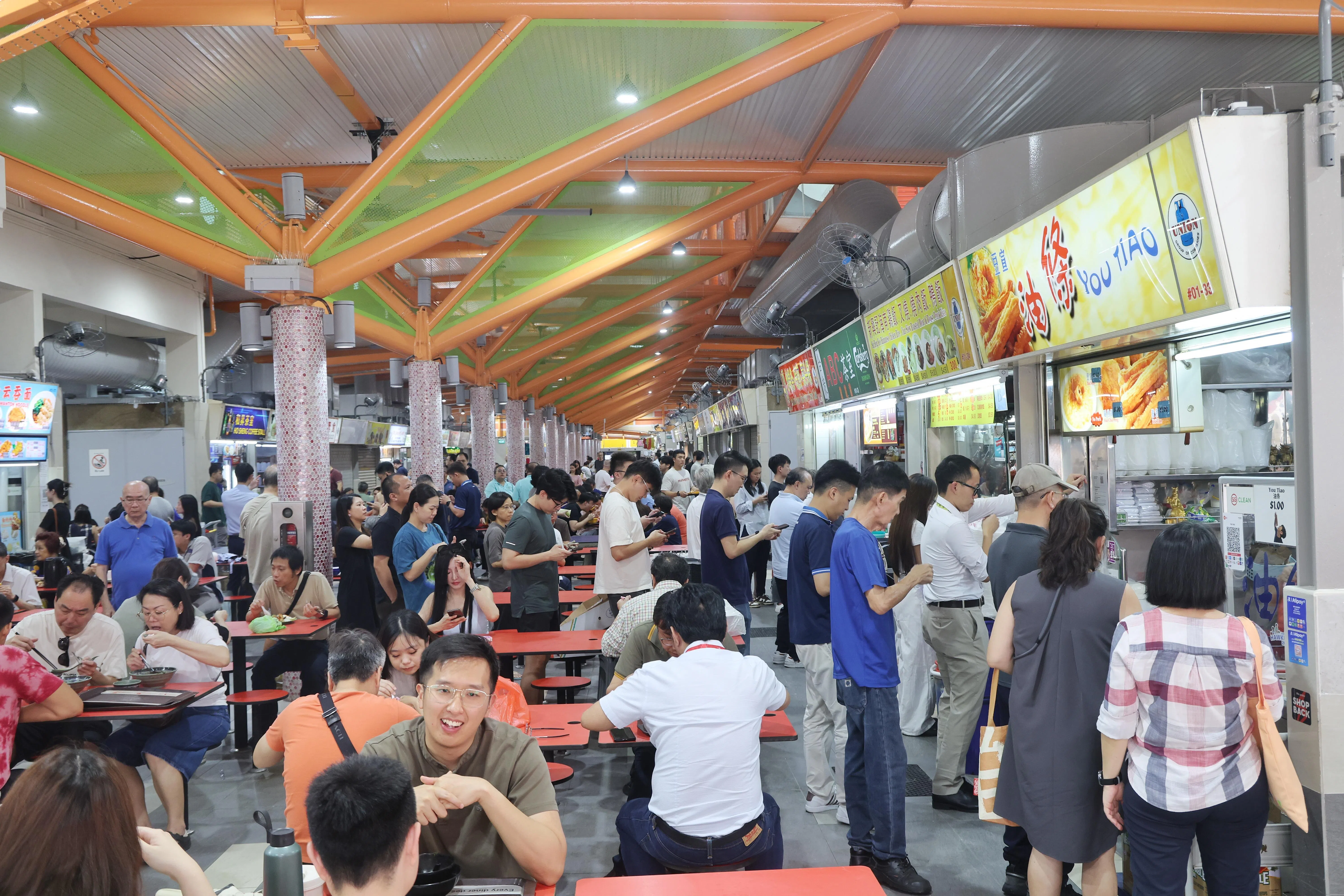 ABC砖厂小贩中心6月初完成整修后，在铁梁柱间加上绿色的铁网格，防止鸟儿停留。摊位招牌上也加装细细的防鸟金属线，让鸟儿不敢立在上方。（唐家鸿摄）