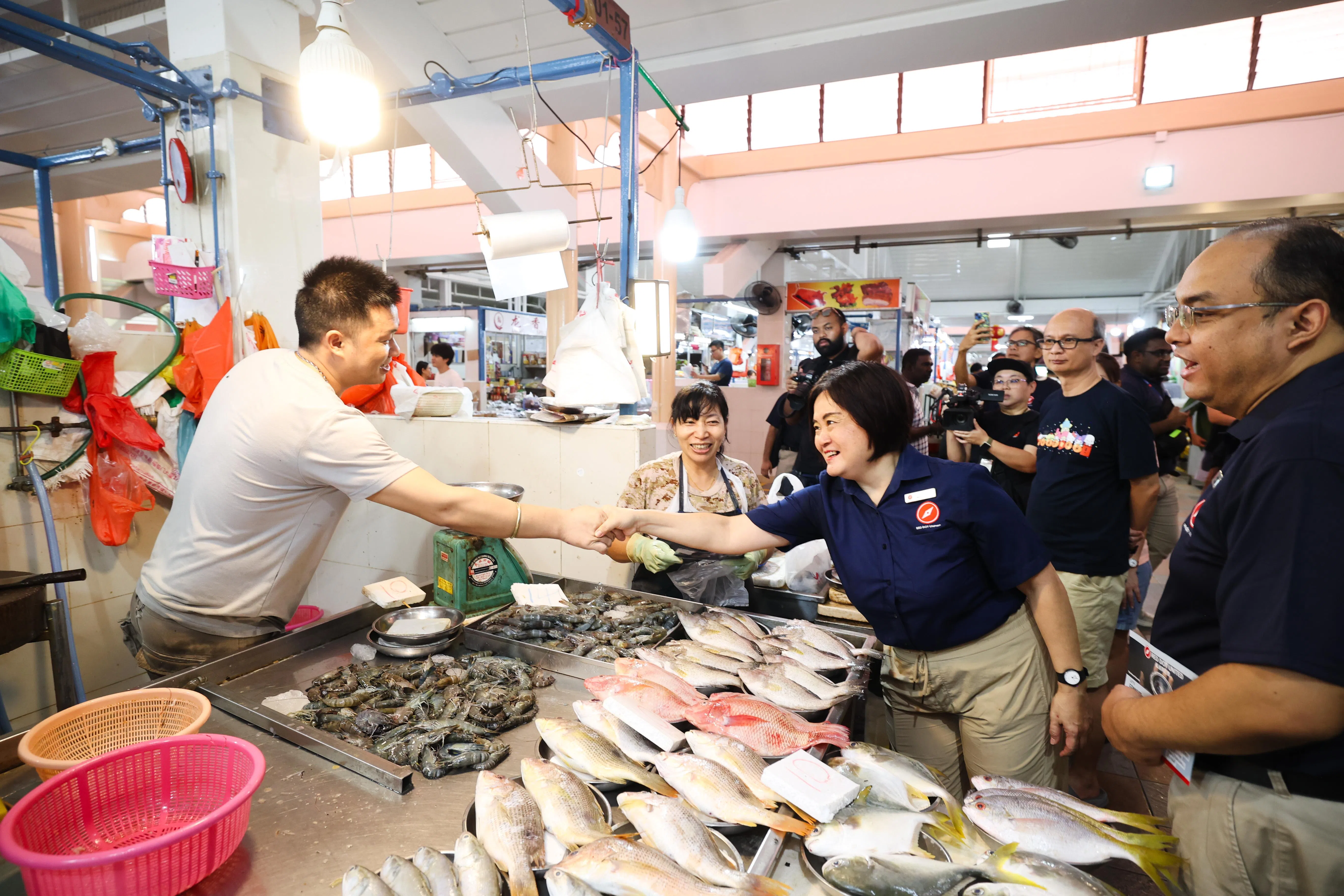 来届大选有意在裕廊中区参选的红点同心党，星期天（3月23日）上午9时许到裕廊东31街的裕华商场一带，向居民介绍59岁的教育工作者胡佳颖（右二）为裕廊中区的基层事务代表。（蔡家增摄）