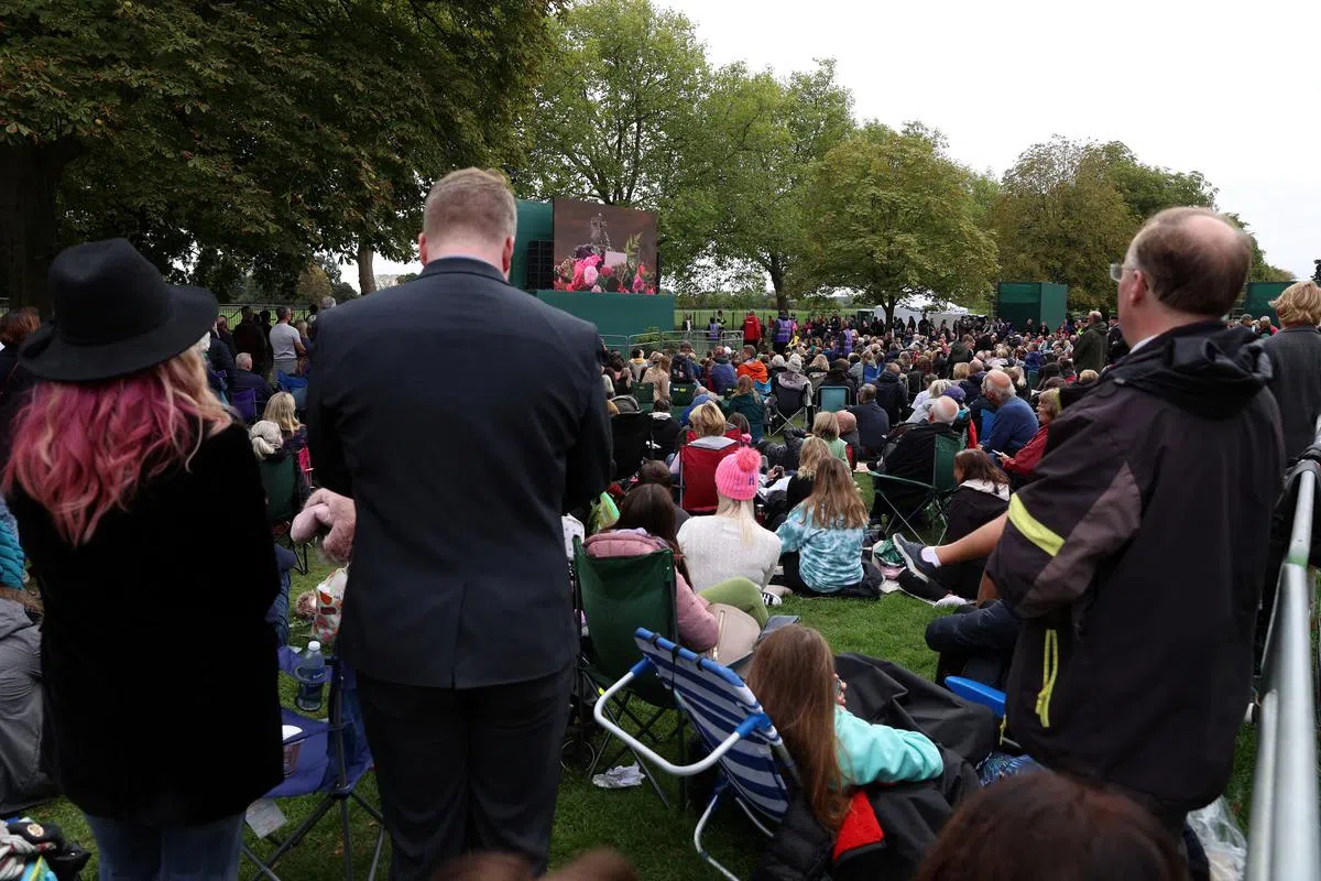 温莎城堡外，民众收看女王国葬直播。（路透社）