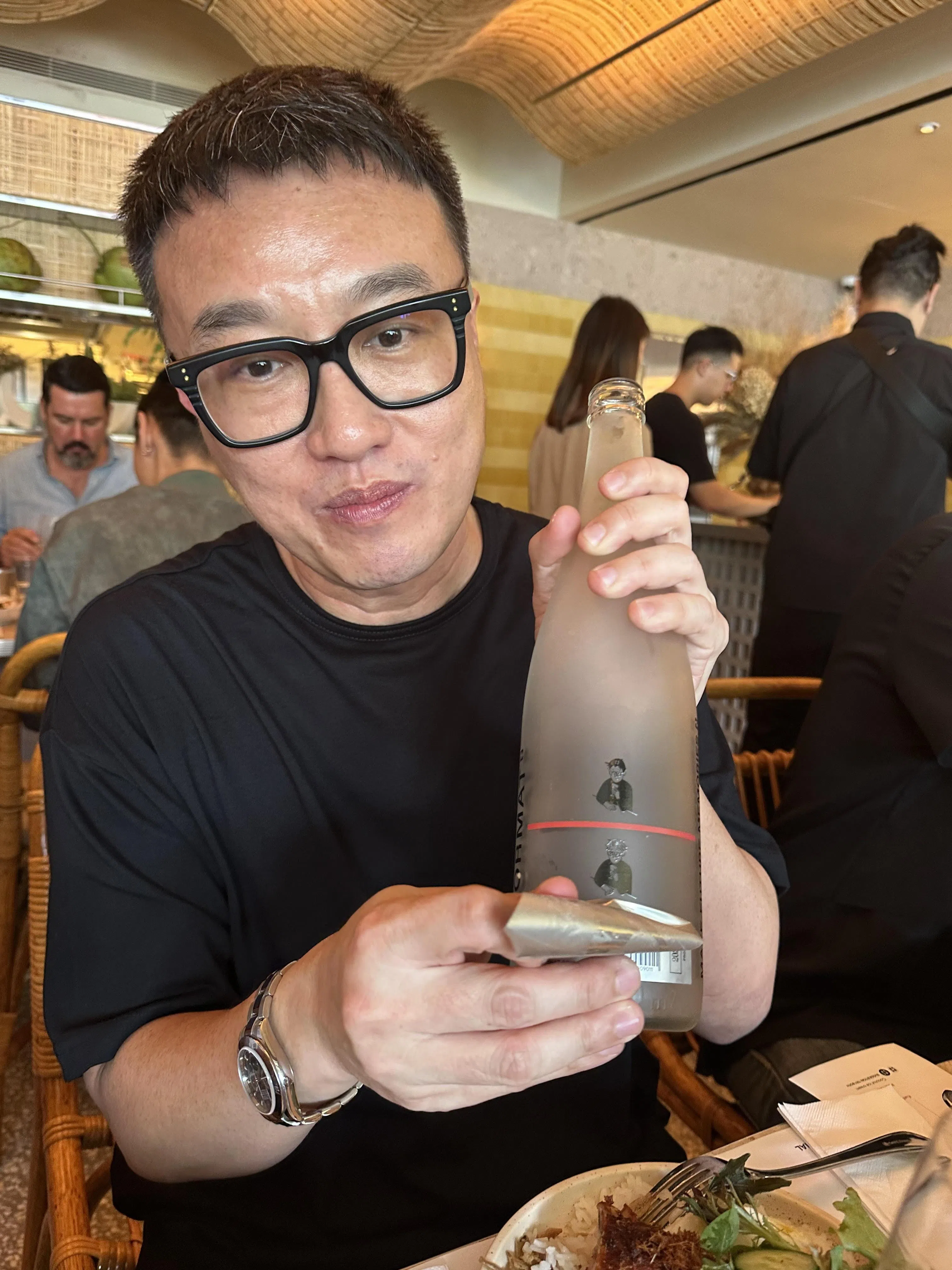 白志玮的清酒瓶设计另有玄机，背后酒标撕下后，出现两个喝酒的男人。（黄向京摄）