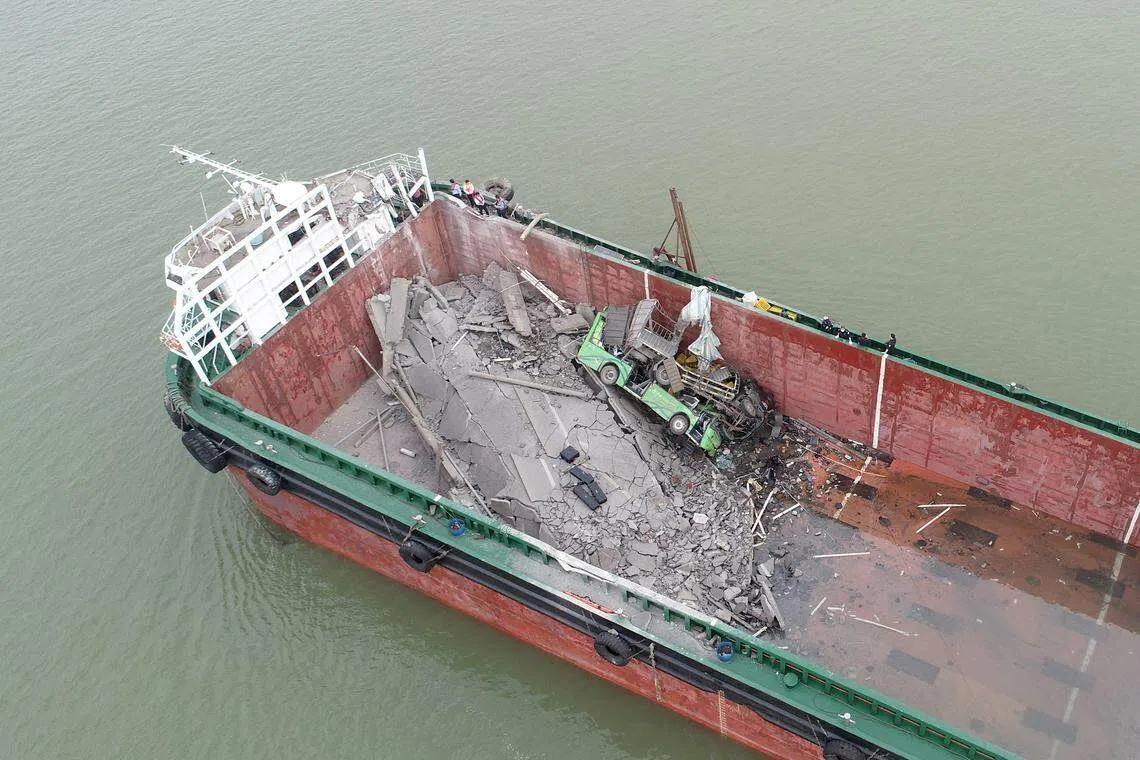 桥面共有四辆车和一辆电动摩托车从断裂处坠落，其中一辆空载中巴车、一辆货车和一辆电动摩托车坠落到集装箱船舱内，两辆小货车掉落水中。（新华社）