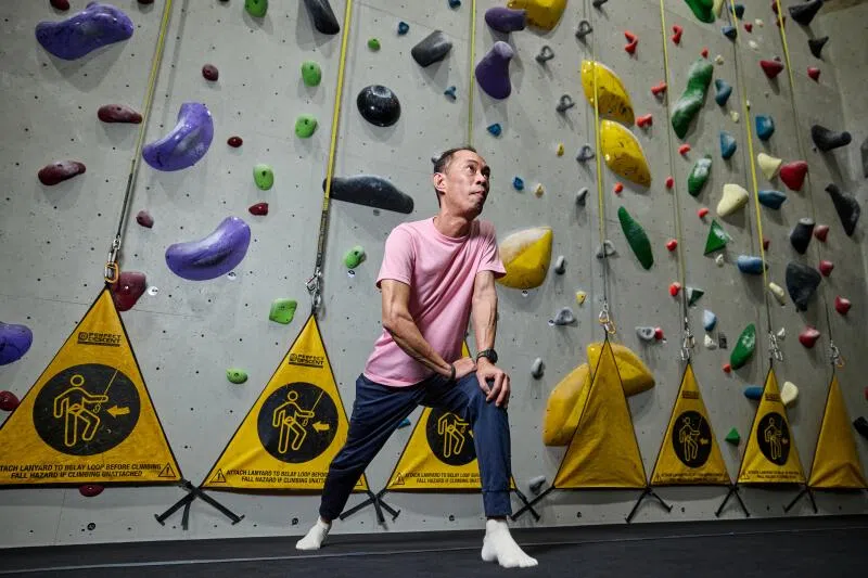 在攀岩墙前的吴宁志，表情专注。他热爱当“蜘蛛侠”。（吴先邦摄）