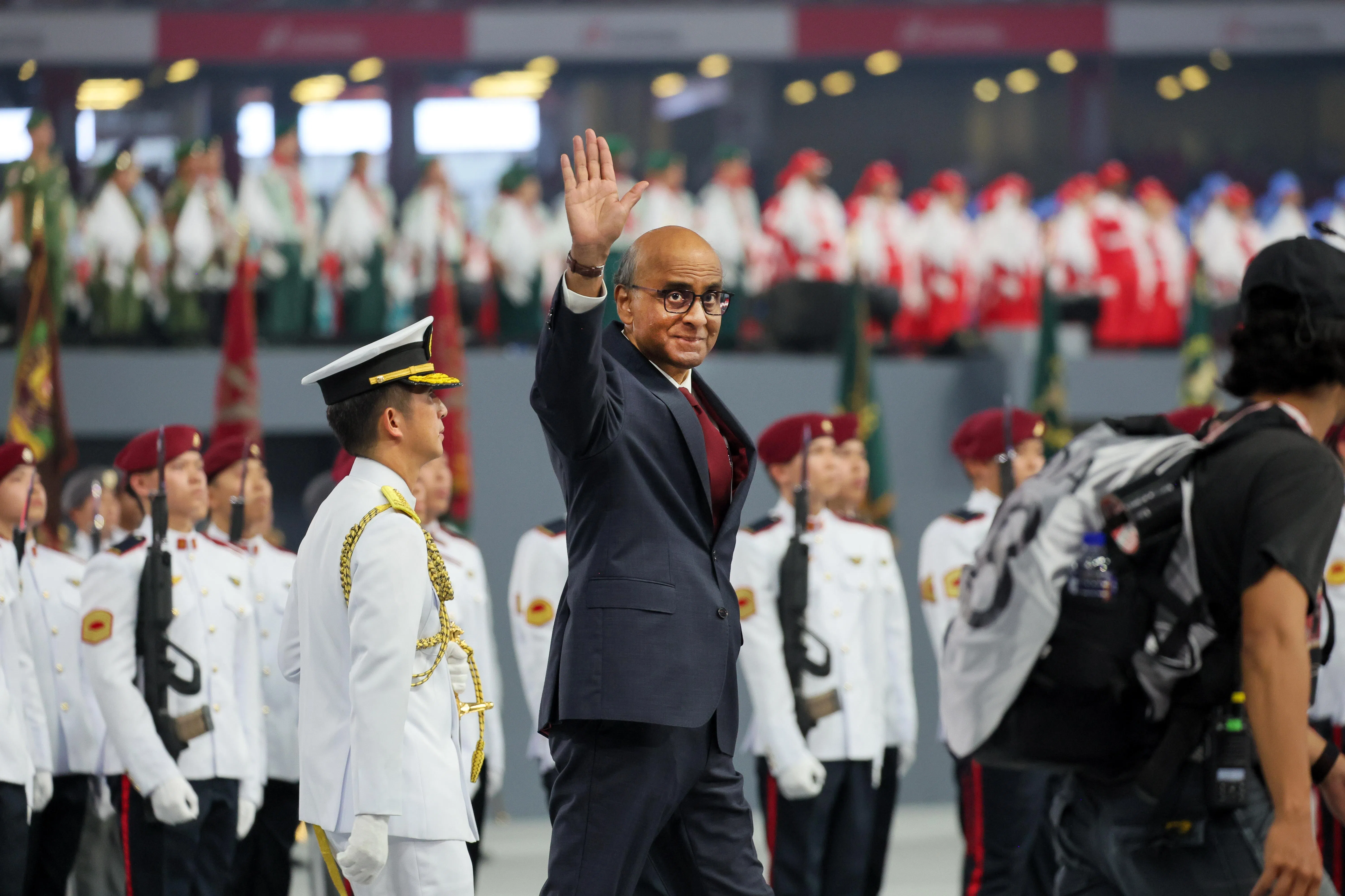 国庆庆典在国家体育场举行，尚达曼总统开始检阅仪仗队之前向到场观众挥手致意。在他右后方的是新加坡武装部队总长孟耀诚中将（侧身）。（张俊杰摄）