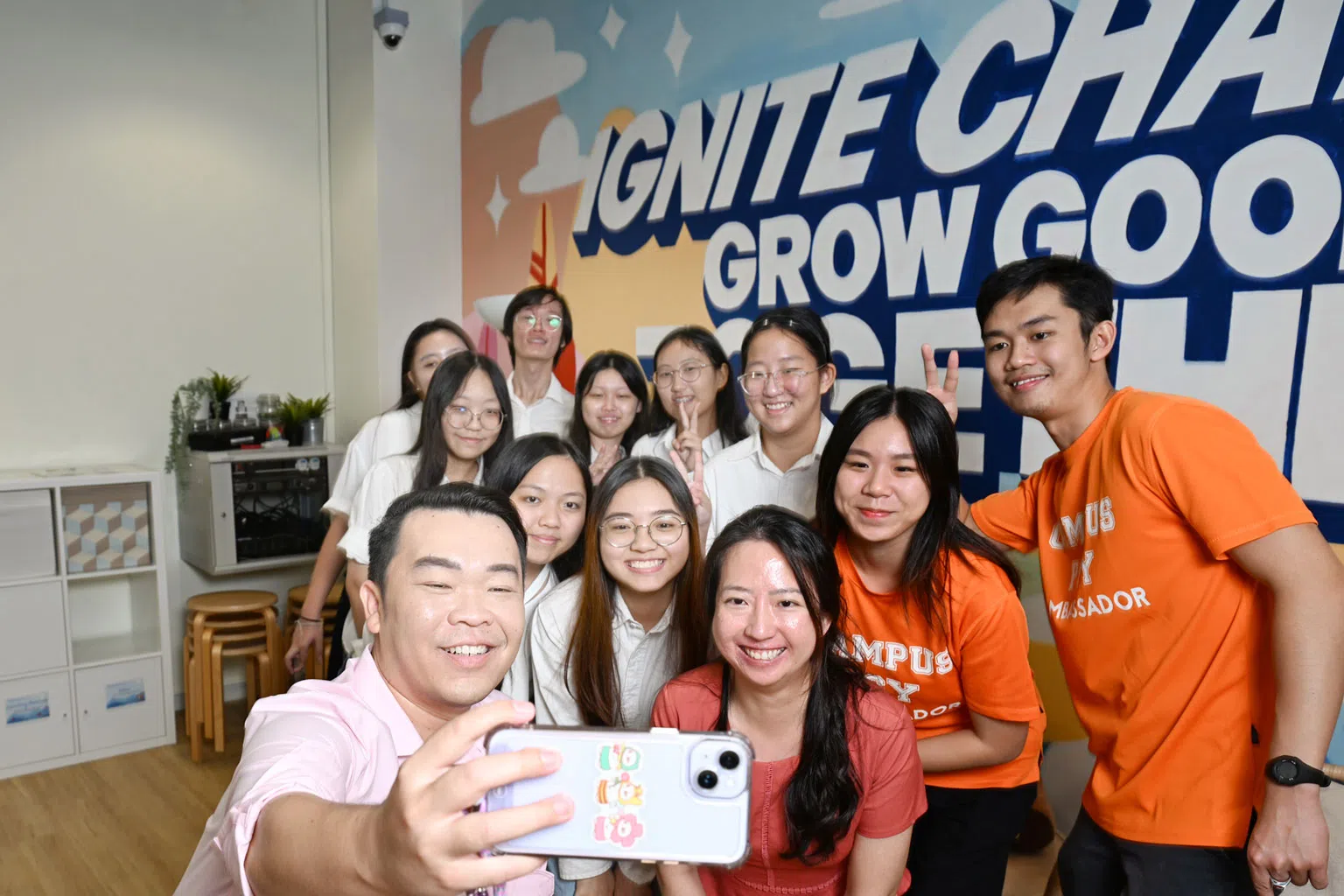 曹铭修（手持手机者）与义安理工学院学生及新加坡青年心理互助支援组织大使在索美塞路的红盒屋一起自拍合照。(档案照)