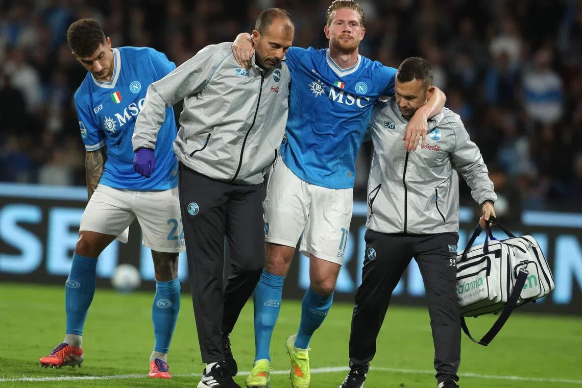 德布吕纳（左三）在球队工作人员的扶持下，落寞离场。（法新社）