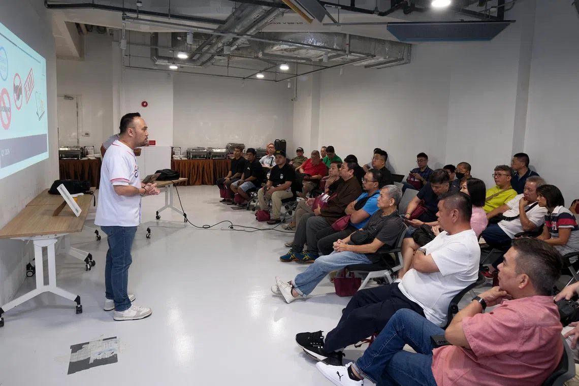 私召车平台Beep Beep去年11月举行司机应用发布会，由创始人之一希金斯（左）向数十名司机阐述平台理念和收费制度。团队随后与司机进一步交流，听取反馈。（曾坤顺摄）