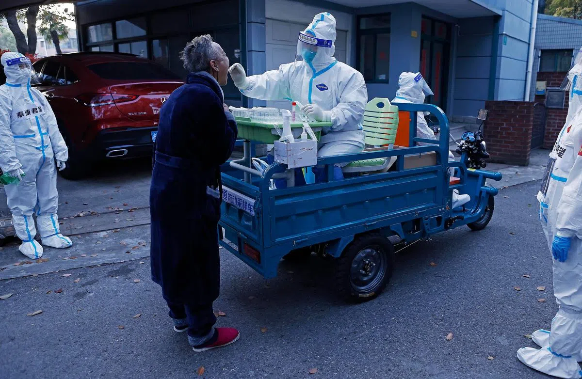 工作人员在上海奉贤区使用流动采样车，为居民提供核酸检测服务。（中新社）