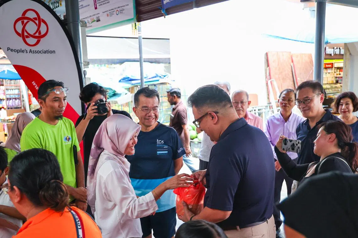武吉巴督东星期六下午碰巧同时举行了两场斋戒月派粥活动，一场由武吉巴督东基层举办，另一场由上届大选角逐裕廊集选区的红点同心党举办。裕廊集选区议员、数码发展及新闻部兼卫生部政务部长拉哈尤（中左）与红点同心党秘书长拉维（中右）碰面时握手寒暄，还交换了各自为居民准备的粥。（林明顺摄）