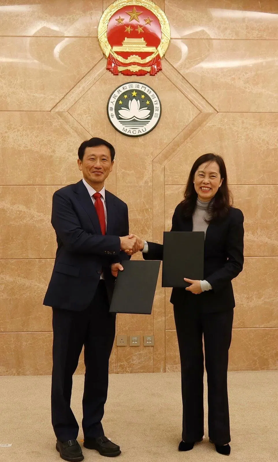 卫生部长王乙康（左）同澳门社会文化司司长欧阳瑜，象征性地交换了有关两地医疗合作的谅解备忘录。（取自王乙康脸书）