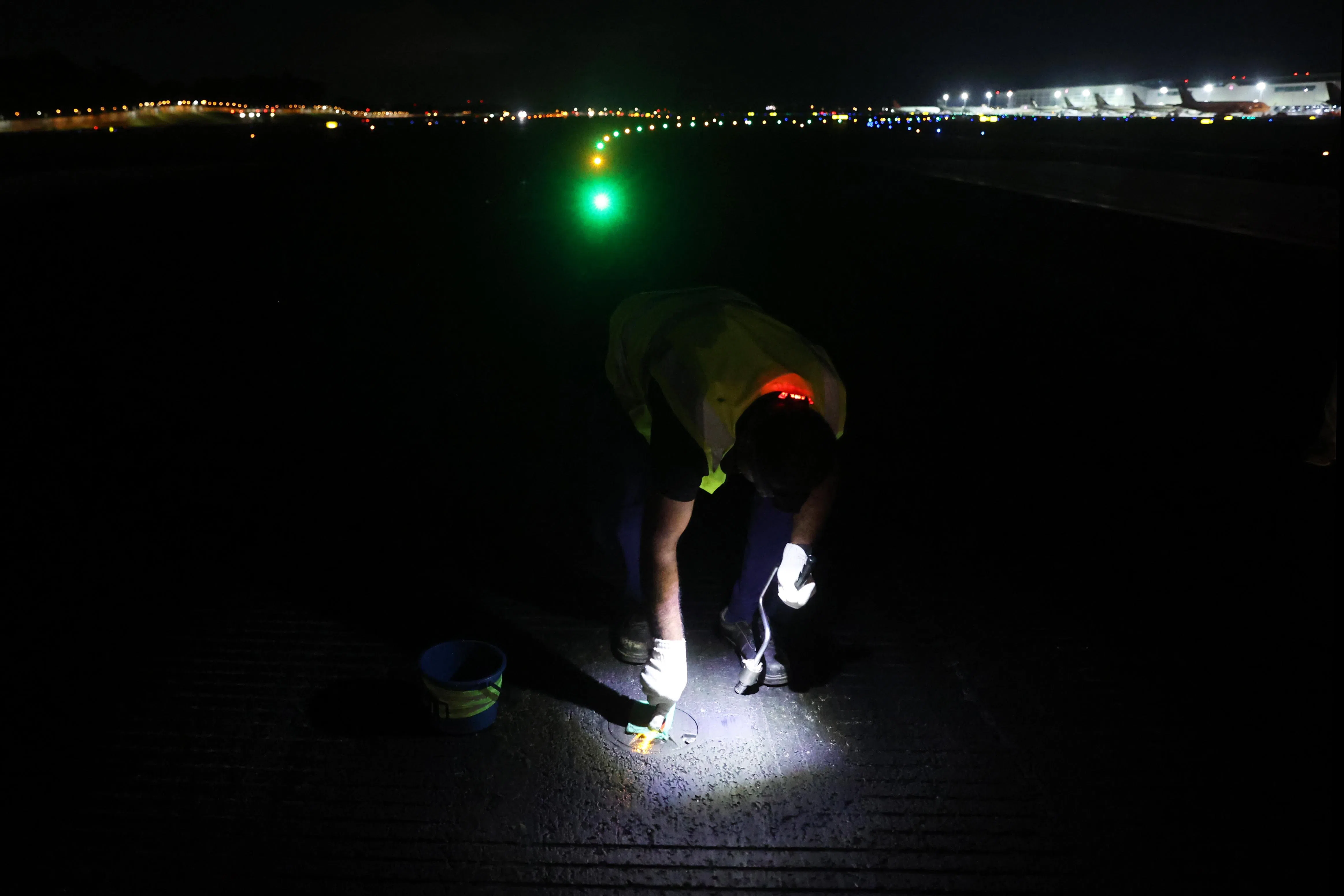 维修人员须在进行光度测量时，逐一清洁跑道边灯。（白艳琳摄）