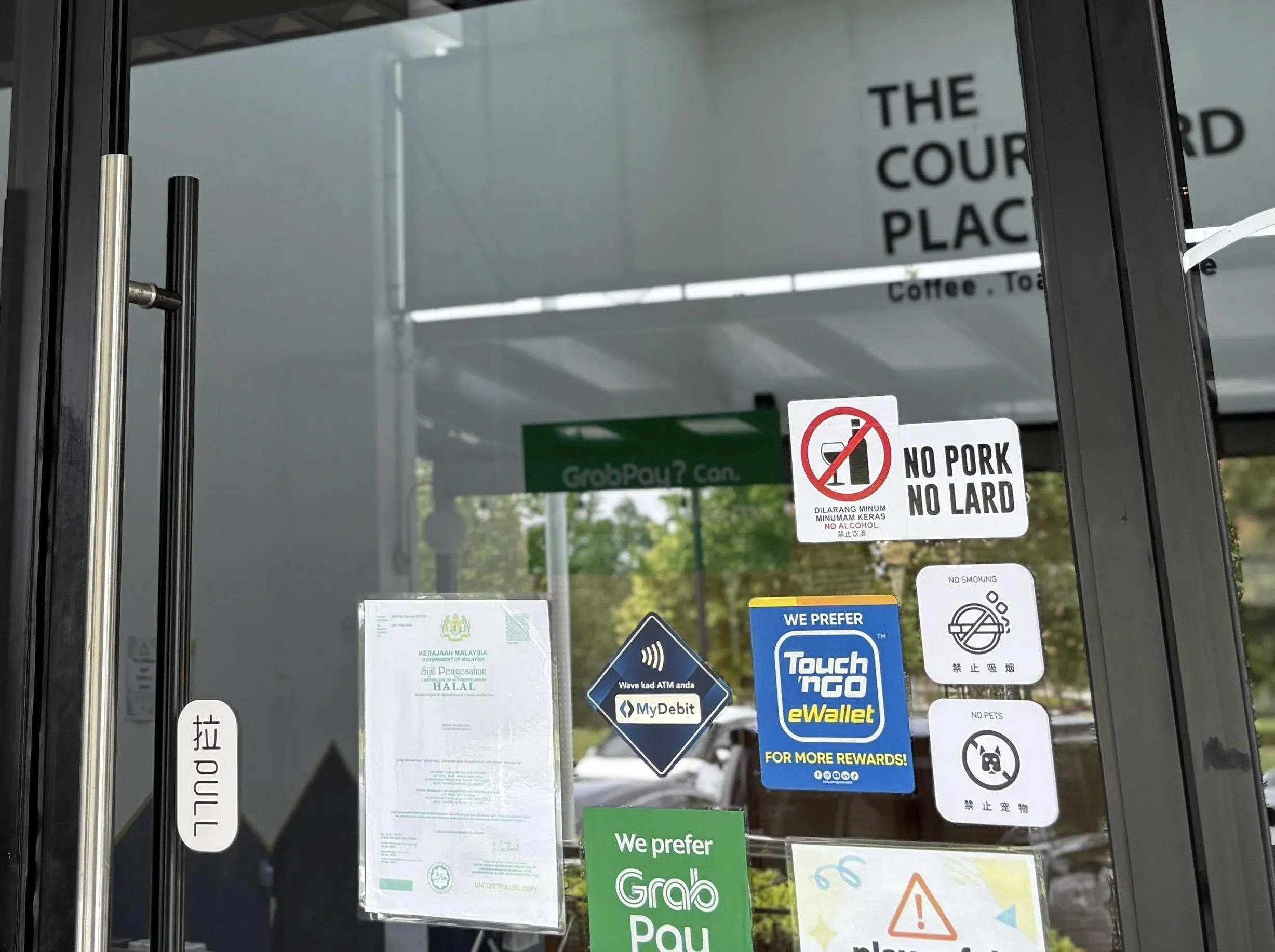 为了吸引回教徒顾客，杨博宇在餐厅外张贴了“没有使用猪肉和猪油”的告示。他希望通过申请清真认证，进一步提高顾客的信心。（受访者提供）