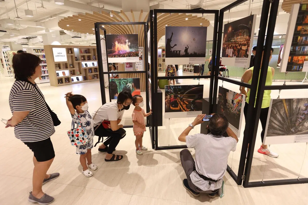 勿洛图书馆的邻里摄影展，展出“定格百年”中的20张黑白与彩色照片，吸引了不少公众前来观赏和记录，这些作品会持续展出至4月底。（梁麒麟摄）