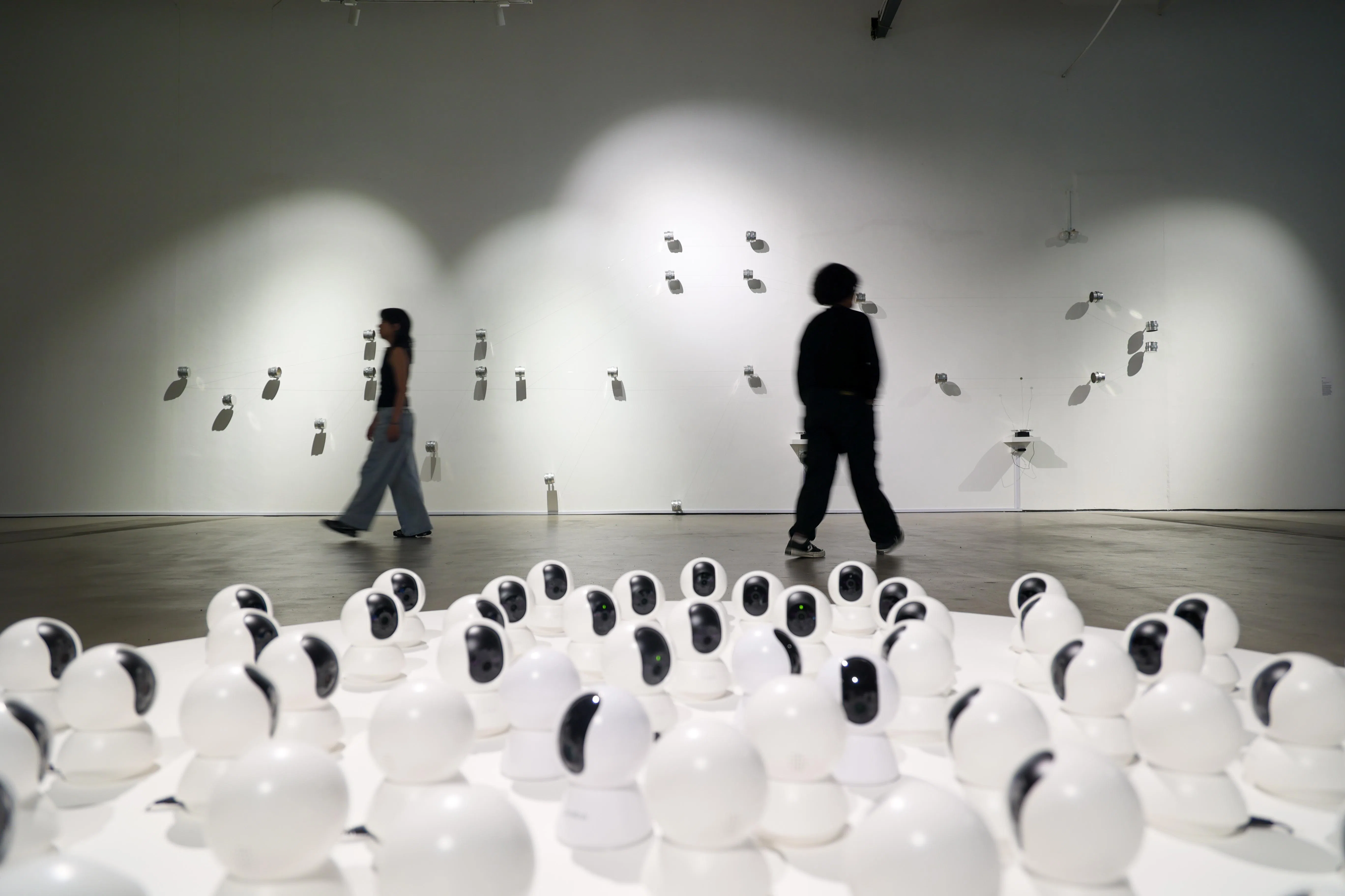 新加坡艺术周期间，新加坡美术馆场内，前景为装置作品“We Are Monitoring The Situation”（意指我们在监督情况），以监控摄像头彼此“对视”，探讨观看与被观看的关系；后方为声音互动装置“Main”（印尼语意为“玩”），以铁罐与连结结构呈现人与人之间的互动与沟通。（张俊杰摄）