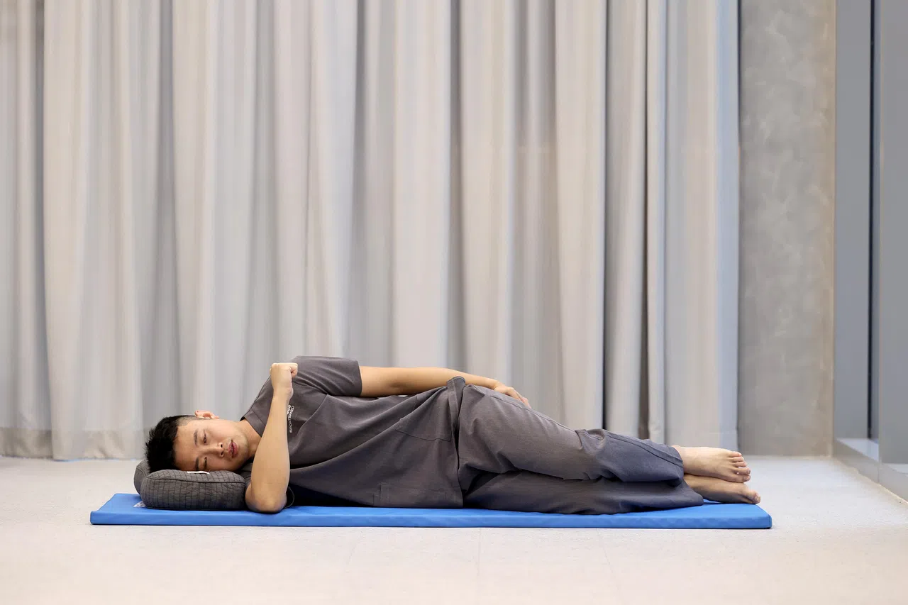 侧躺，要伸展的手臂在下。（关俊威摄）